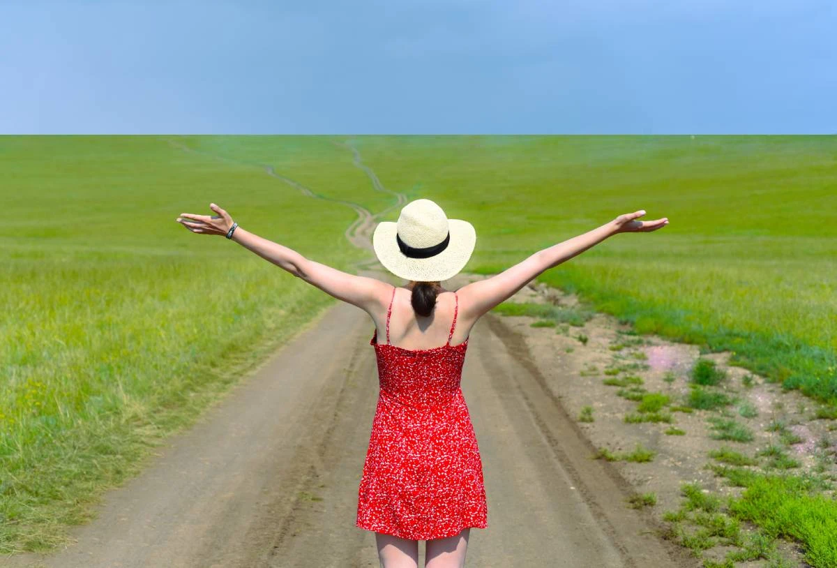 Cute girl in a red dress in a field