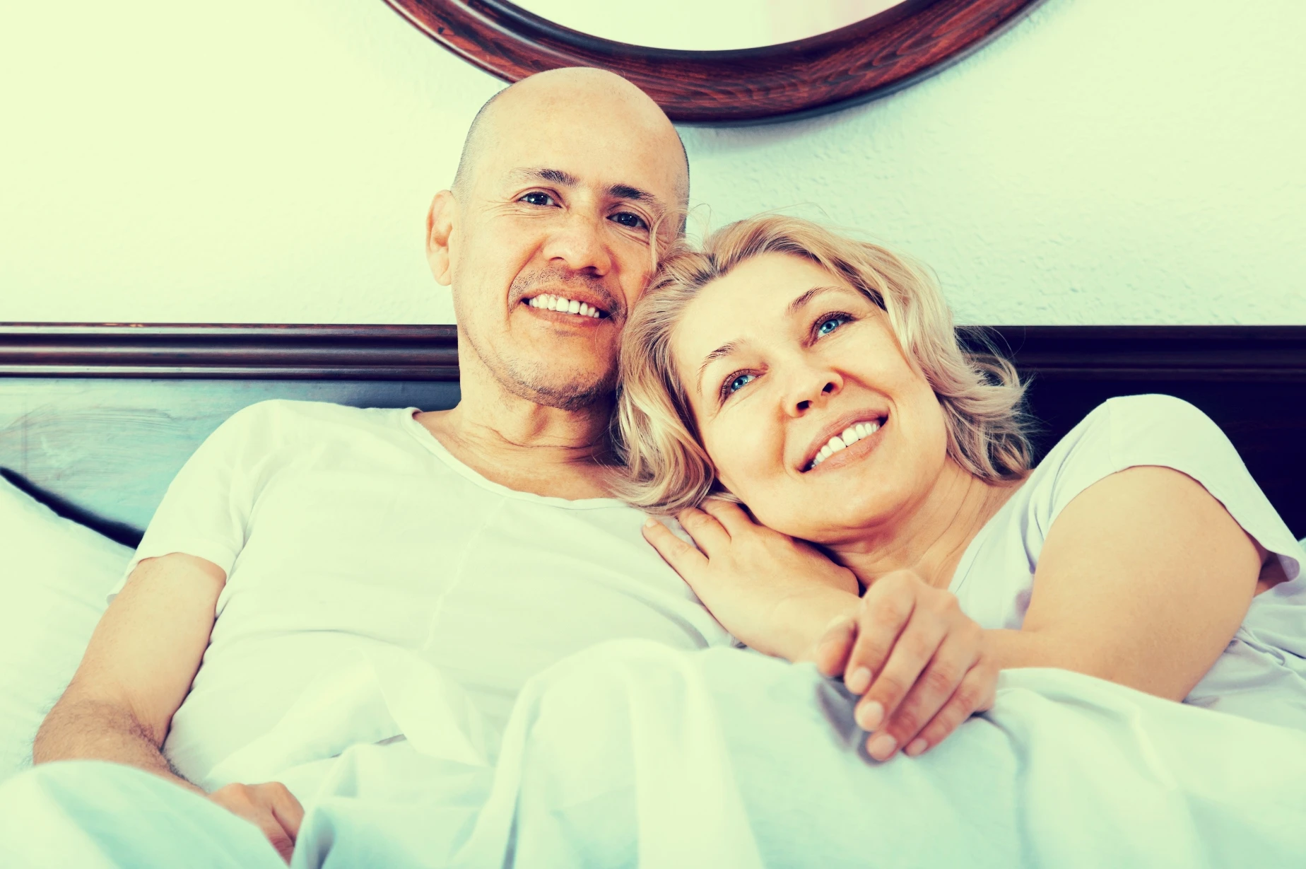 Happy older couple snuggling in bed