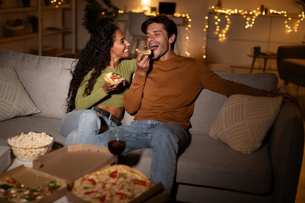 Man and woman smiling with a rose on the couch